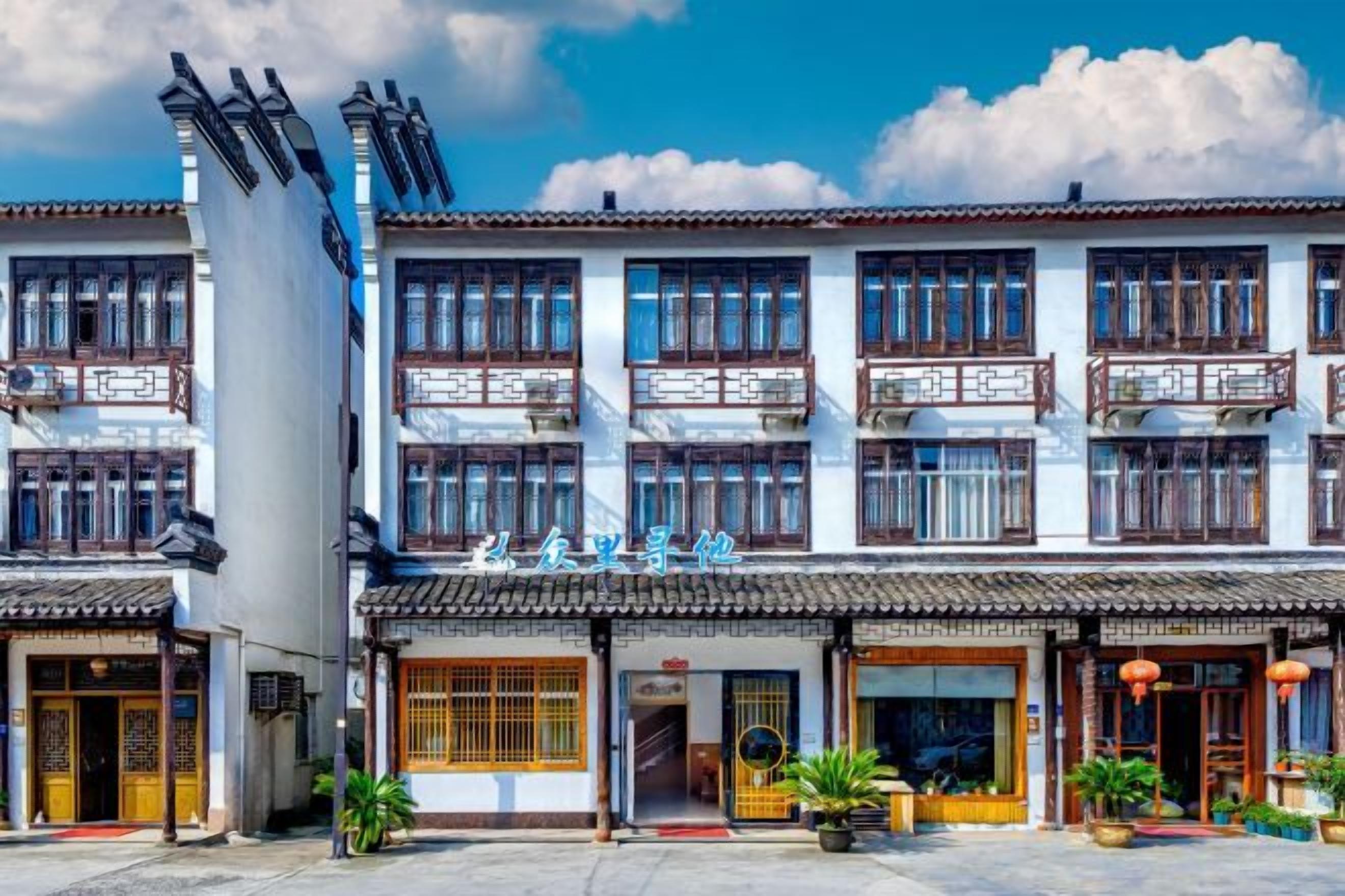 A traditional multi-story building with a tiled roof, multiple balconies, and a sign indicating a restaurant or cafe.