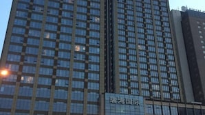 Un immeuble de grande hauteur, doté d’une façade à motifs géométriques et d’une enseigne indiquant « 瑞港国际 ».