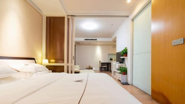 Une chambre d’hôtel avec un grand lit, un bureau et une kitchenette.