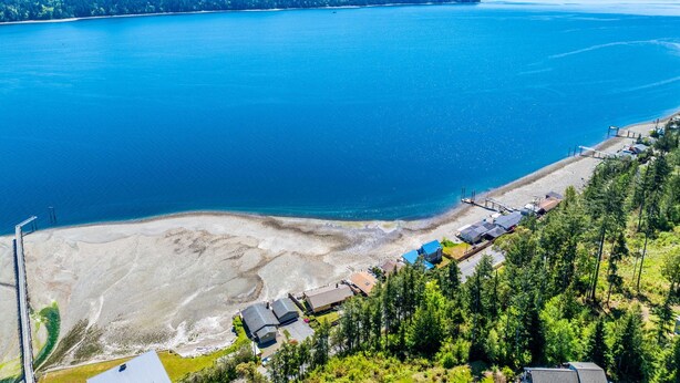 A coastal area with a beach, a pier, and buildings along the shore. - Waterfront Retreat, Relaxation, Fun in Hood Canal (Hoodsport)