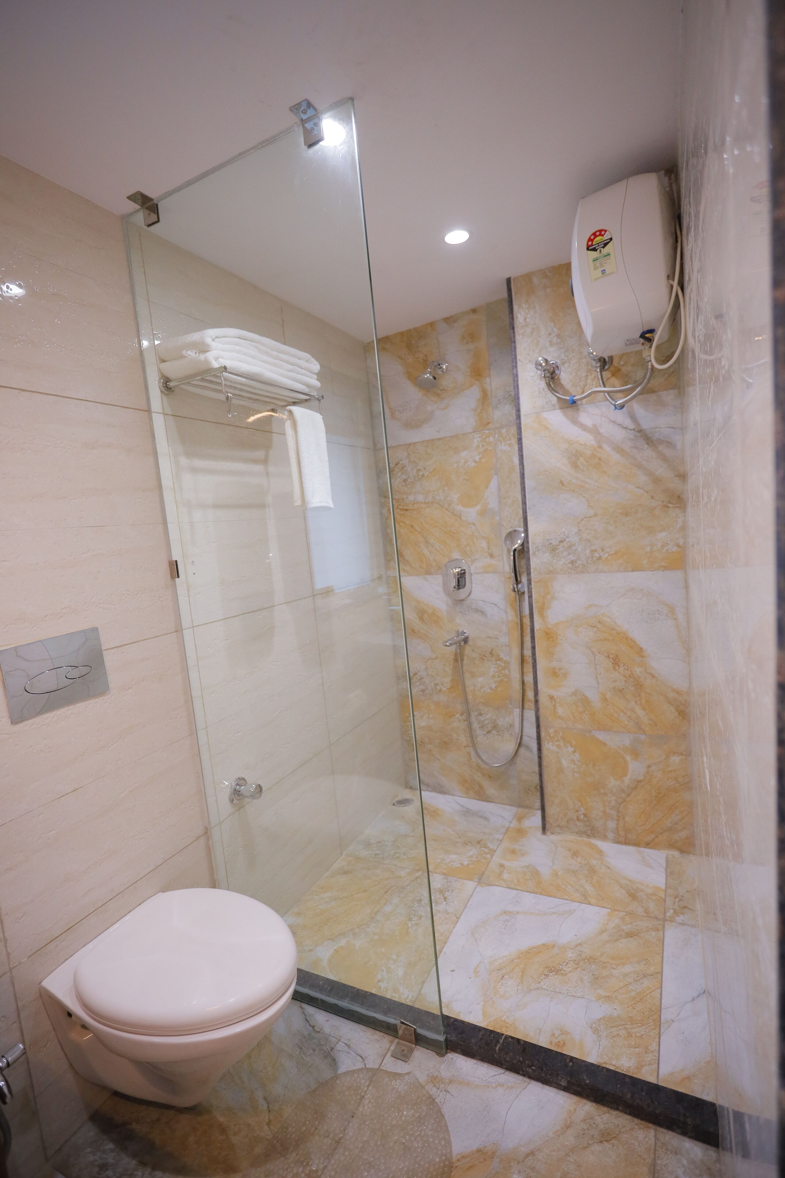 A modern bathroom with a glass-enclosed shower, a toilet, and a towel rack.