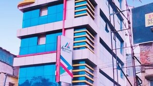 A multi-story hotel with a modern facade, featuring a prominent logo and signage indicating it is the "Avenue Hotel."