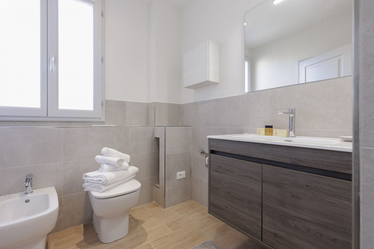 Un baño moderno con bidé, inodoro y tocador.