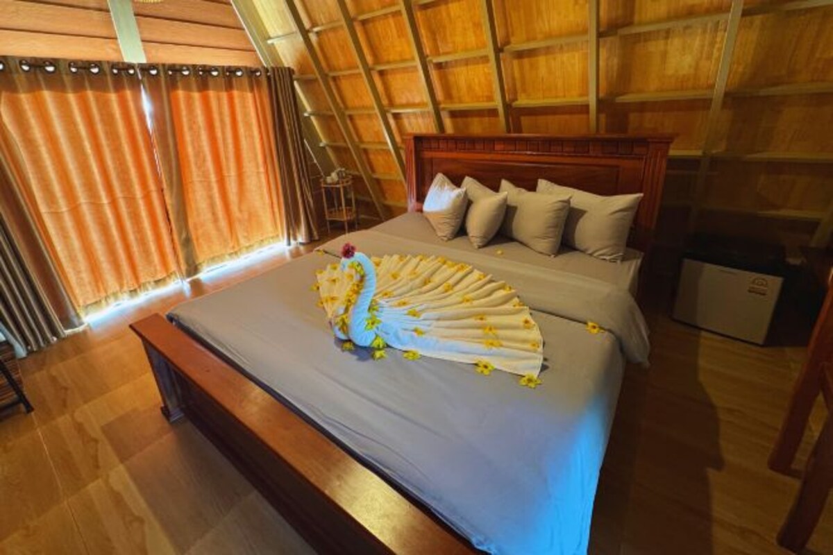 A bedroom with a bed, wooden headboard, and a bench.