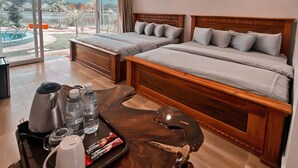 A hotel room with two beds, a coffee table with a tray of breakfast items, and a view of a swimming pool and mountains. - Bali Villa Kampot (Kampot)