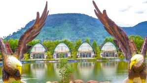 A row of four-roomed cottages with a lake and mountains in the background. - Bali Villa Kampot (Kampot)