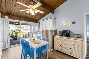 Enjoy a spacious living area with a kitchenette, dining table, and ceiling fan.