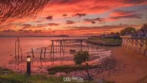 A beach with a sunset, wooden structures, and a lamp post. - SkyStarSea Pension (Muan)
