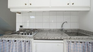 A kitchen with white cabinets, a granite countertop, a stainless steel sink, and a dishwasher.