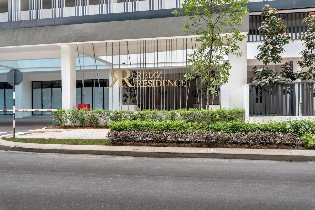 Un bâtiment moderne sur lequel on peut lire l’inscription : « RÉSIDENCE REIZZ ».