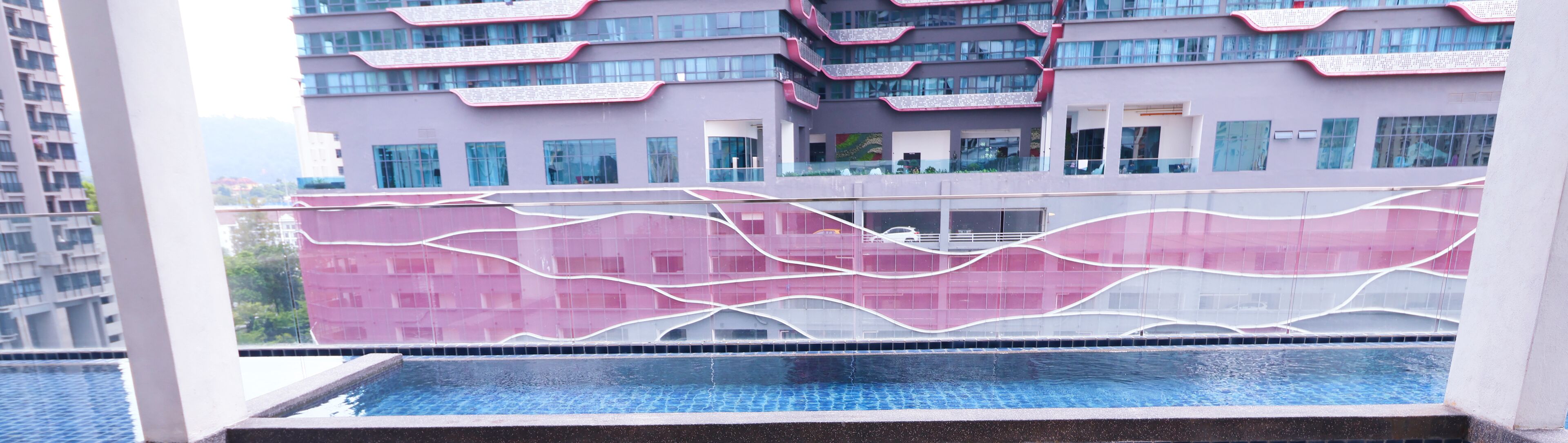 Un bâtiment moderne avec une piscine en premier plan.