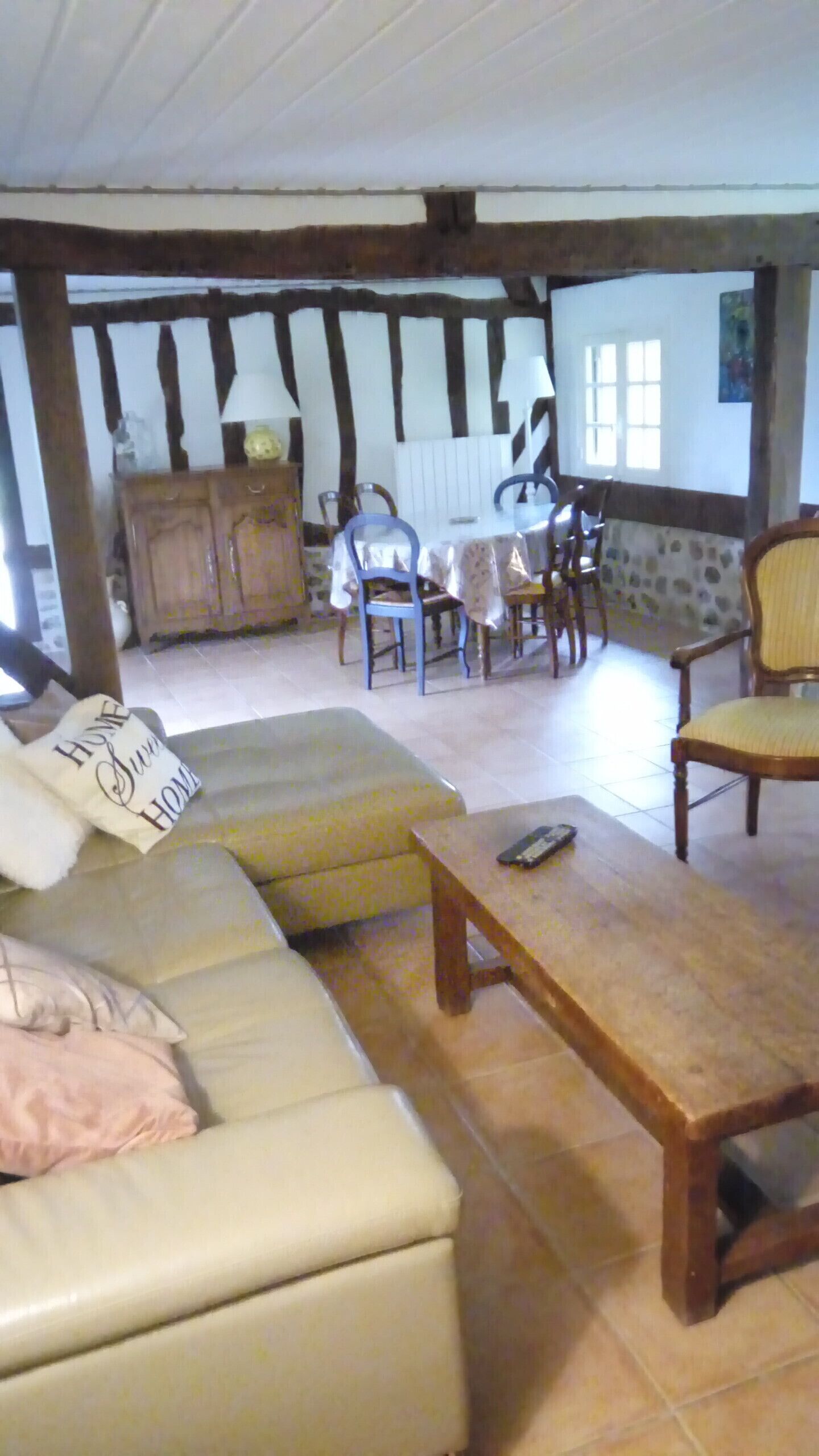 A cozy living room with a sofa, a wooden coffee table, and a dining area with a table and chairs.