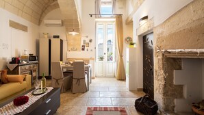 Ein gemütliches Wohnzimmer mit Kamin, Essbereich und einer Küche mit Steinwand.