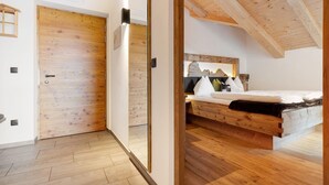 A bedroom with a wooden ceiling, a bed with pillows, and a wooden floor. - Holiday Apartment 'Platiederhof Apt Lajen' with Mountain View, Shared Garden & Wi-Fi (Laion)