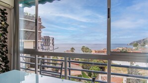 A balcony with a view of the sea and buildings.