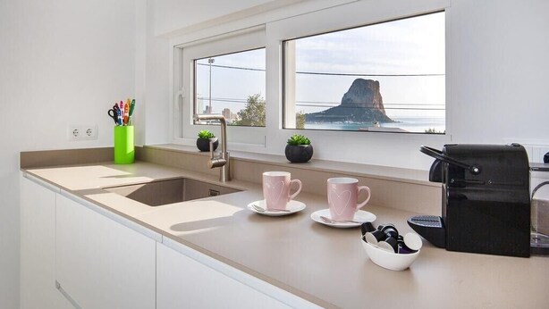 A modern kitchen with a large window, a sink, and a coffee machine. - Villa "Bennu - Lujo Y Confort" near Beach with Private Pool & Wi-Fi (Calpe)