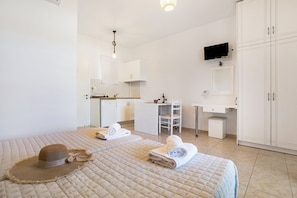 A hotel room with a bed, a desk, a chair, a TV, and a wardrobe. - Holiday Apartment "Tropical 4" with Shared Garden, A/C & Wi-Fi (Zakynthos)