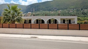 Un bâtiment doté d’un toit plat, d’une clôture en bois et offrant une vue dégagée sur une montagne en arrière-plan.