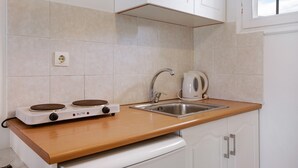 Una cucina con fornello, lavello e pensili.