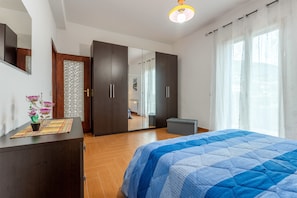 A bedroom with a bed, a wardrobe, a mirror, and a window with curtains. - Holiday Home "Casa Splendida" with Mountain View, Terraces & Wi-Fi (Monreale)