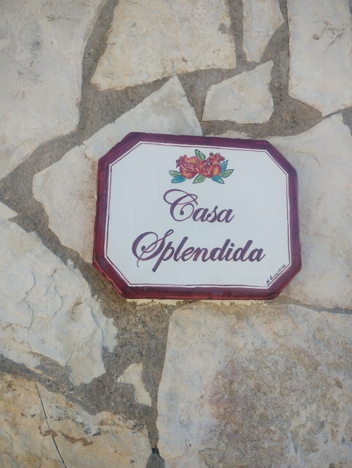Ein Schild mit dem Schriftzug 'Casa Splendida' an einer Steinwand.