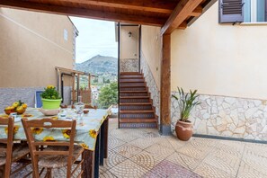 A patio with a table set for dining, a staircase, and potted plants. - Holiday Home "Casa Splendida" with Mountain View, Terraces & Wi-Fi (Monreale)