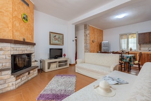 A living room with a fireplace, sofa, and a television. - Holiday Home "Casa Splendida" with Mountain View, Terraces & Wi-Fi (Monreale)