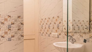 Une salle de bain comprenant des toilettes, un lavabo et un espace douche.