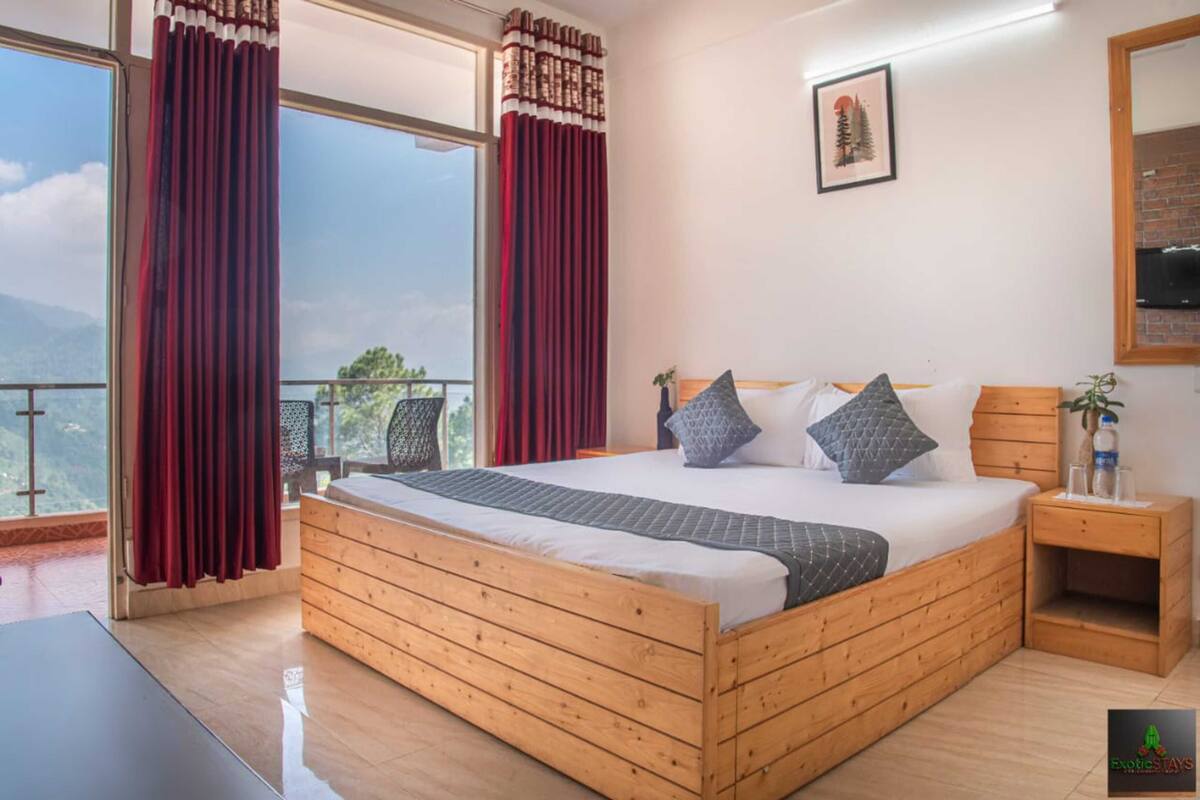 Ein Schlafzimmer mit einem hölzernen Bett, einem Nachttisch und Blick ins Freie.