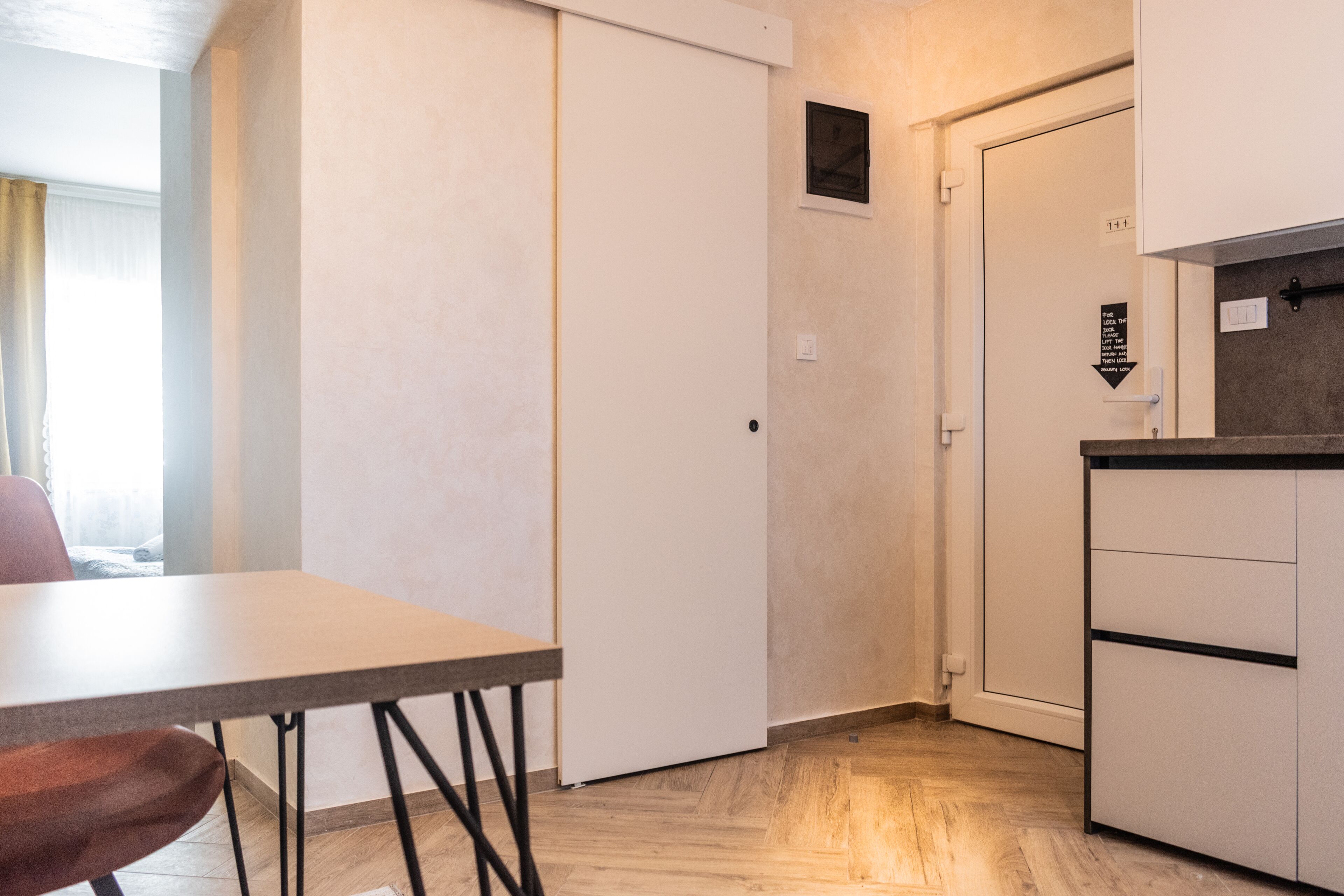 A compact kitchen with a dining area, a sliding door, and a small window.