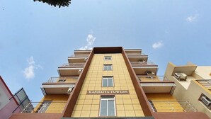 A multi-story building with balconies and the name "KANHAIYA TOWERS" on the facade. - Hotel Habitat Comforts (Bengaluru)