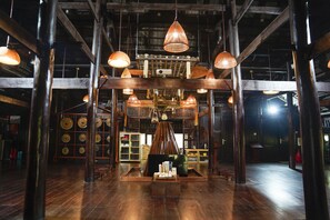 A spacious room with high ceilings, exposed wooden beams, and hanging pendant lights. - MEDDOM Park (Thung Nai)
