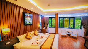 A hotel room with a large bed, bedside tables, a desk, and a chair. There are windows with curtains, a ceiling light, and a wall-mounted TV. - MEDDOM Park (Thung Nai)