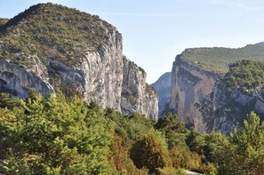 Un paysage montagneux caractérisé par des falaises rocheuses et une forêt dense.