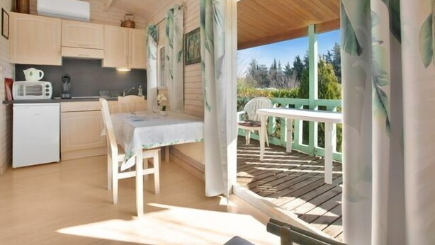 A cozy kitchen with a dining area, a small refrigerator, and a table with chairs. - Quiet chalet 10 minutes from the beach (Roquebrune-sur-Argens)