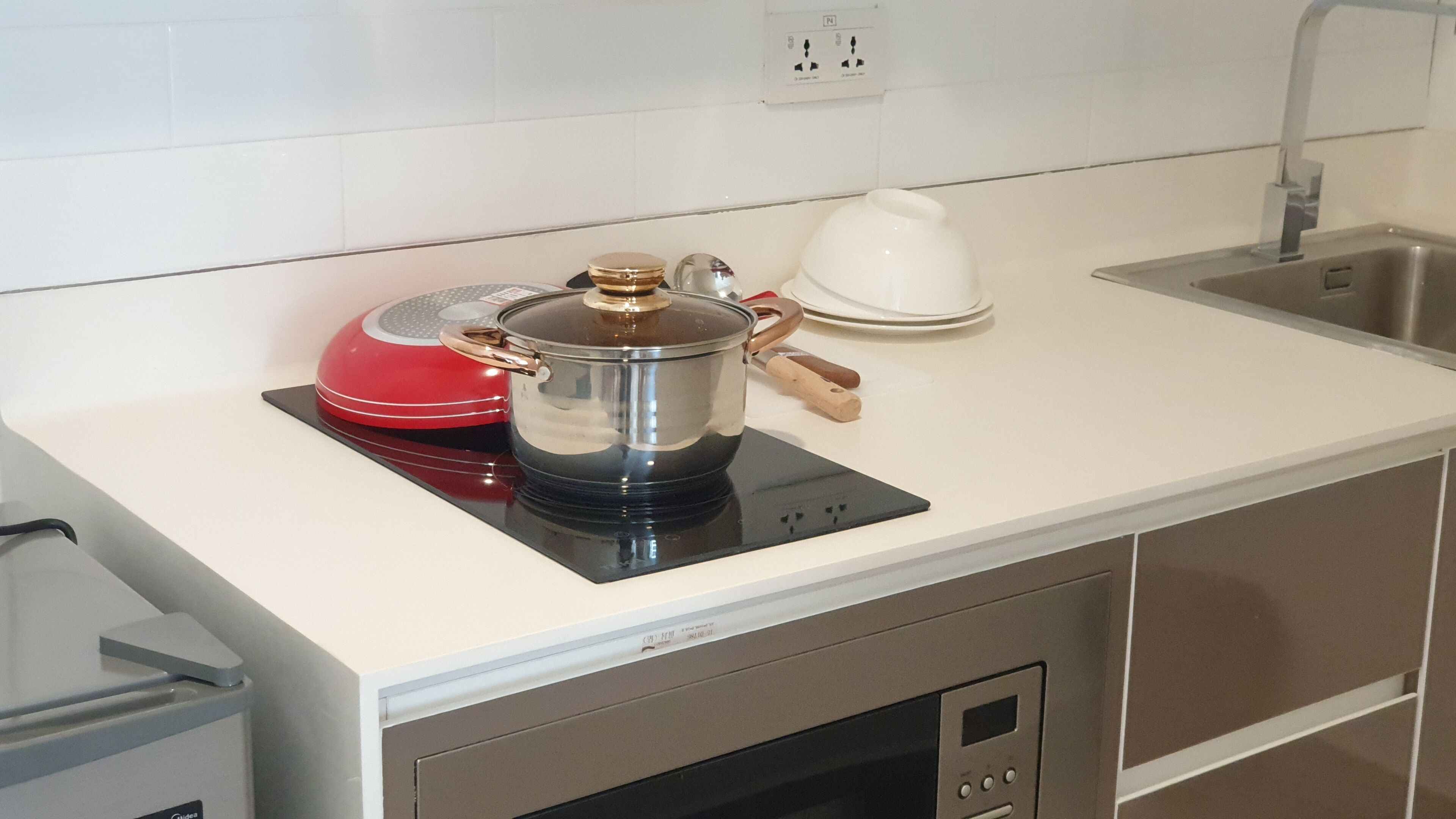Une cuisine équipée d’une cuisinière, d’une bouilloire et d’un évier.