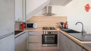 Eine moderne Küche mit Mikrowelle, Herd, Backofen und Spüle.