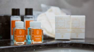 A bathroom counter with various toiletries including bottles of shampoo and soap.