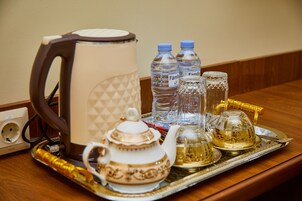 A tray with a teapot, two water bottles, a glass carafe, and a kettle.