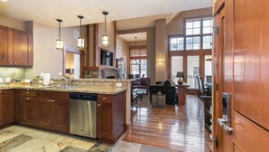 A spacious kitchen with granite countertops, wooden cabinets, and a built-in dishwasher. - Catamount Lodge 408 Fabulous 2 Bedroom (Truckee)