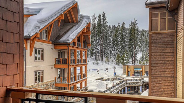A multi-story building with a balcony, wooden beams, and a snow-covered landscape. - Catamount Lodge 408 Fabulous 2 Bedroom (Truckee)