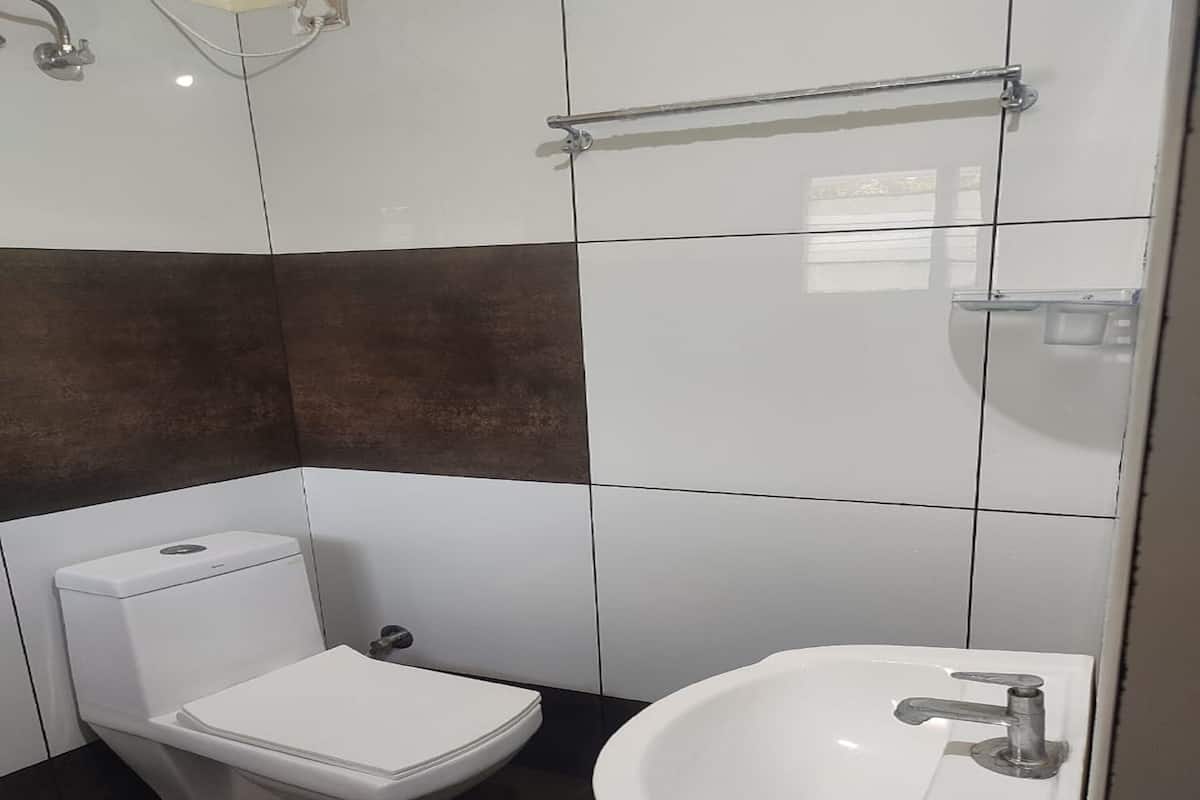 A bathroom with a toilet, sink, and a towel rack.