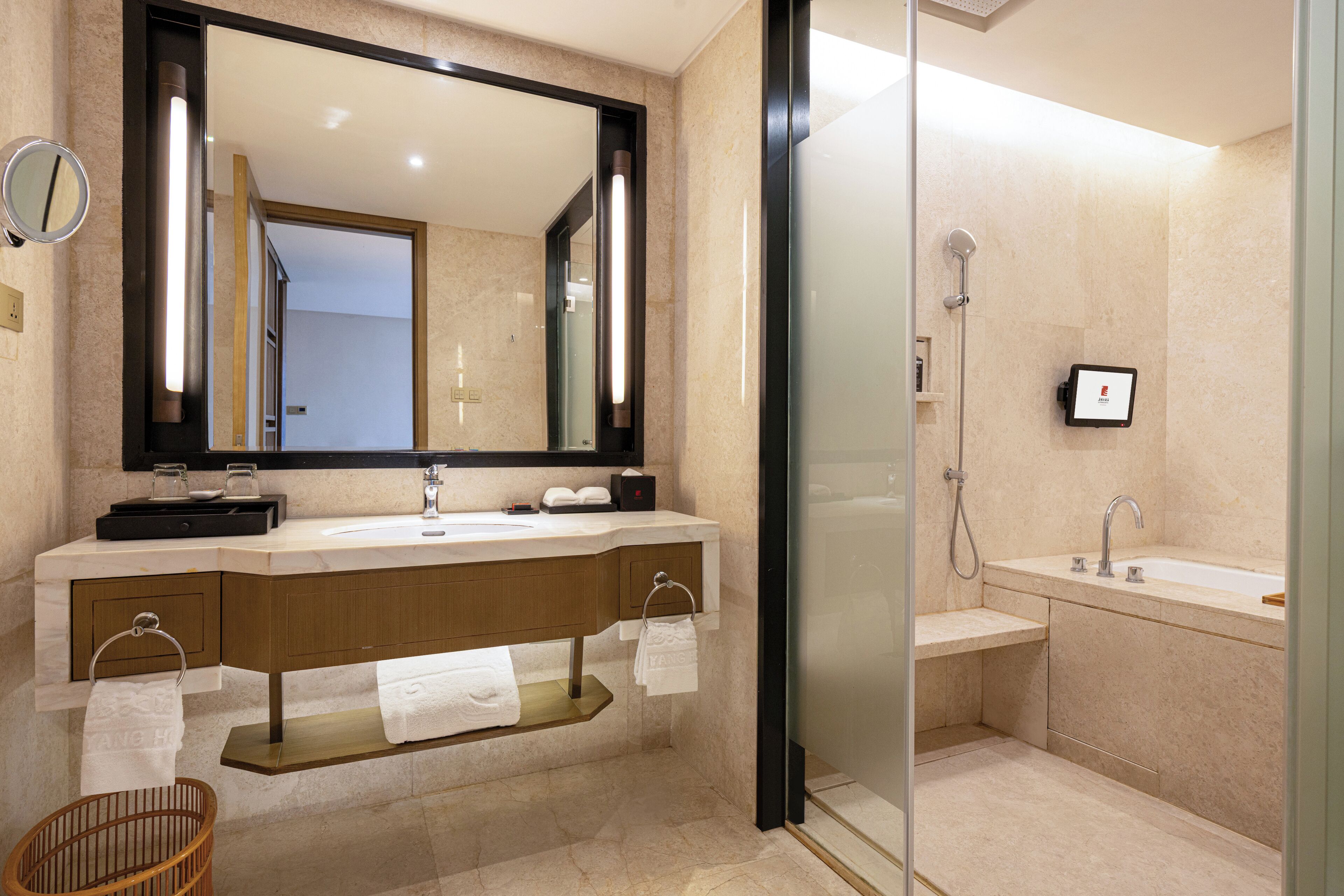 Een moderne badkamer met een grote spiegel, een wastafelmeubel met een wastafel, een douchegedeelte en een douchecabine met glazen wanden.