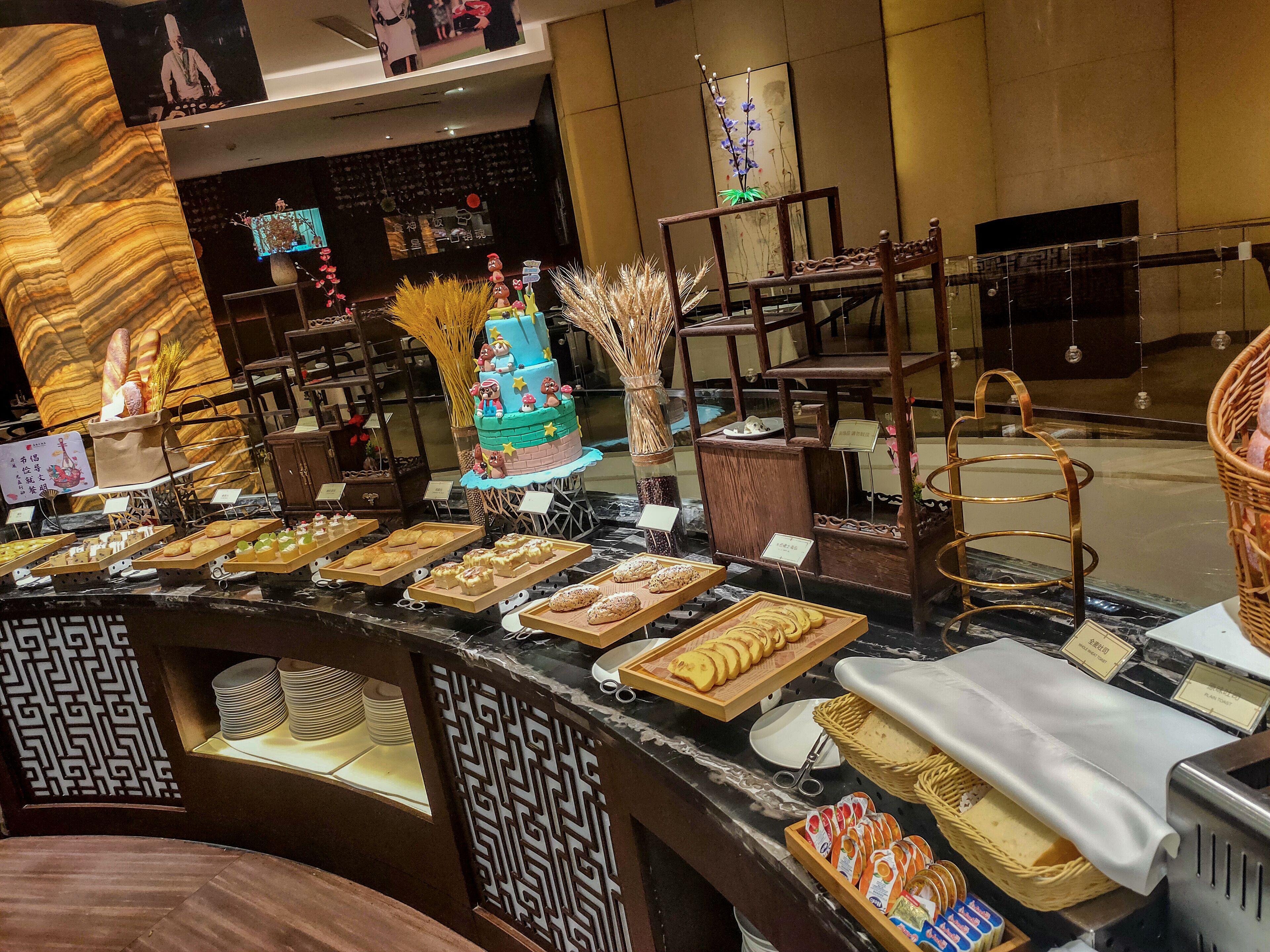 A buffet area with various food items and a decorative cake.