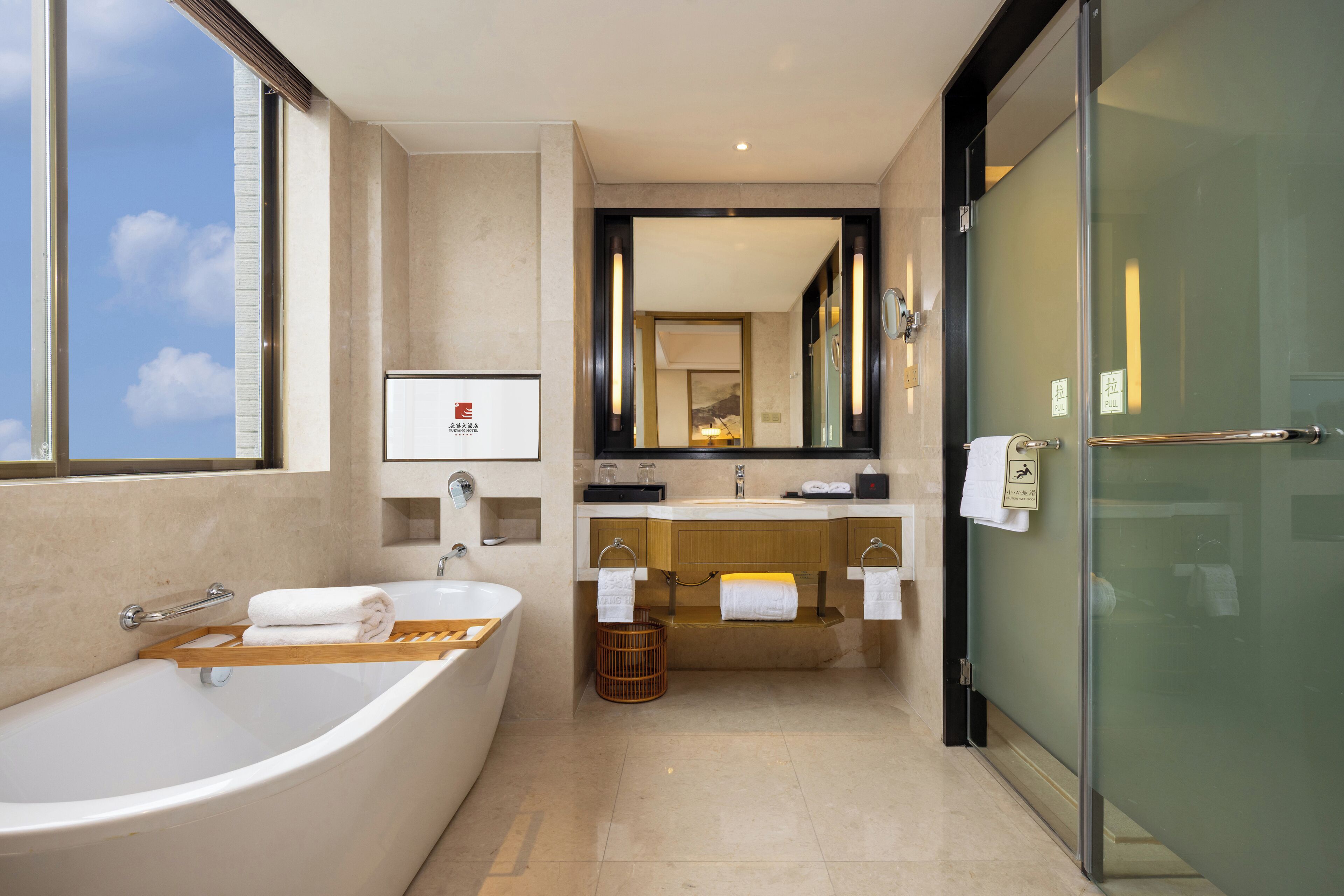 A modern bathroom with a large bathtub, a vanity with a mirror, and a glass shower enclosure.