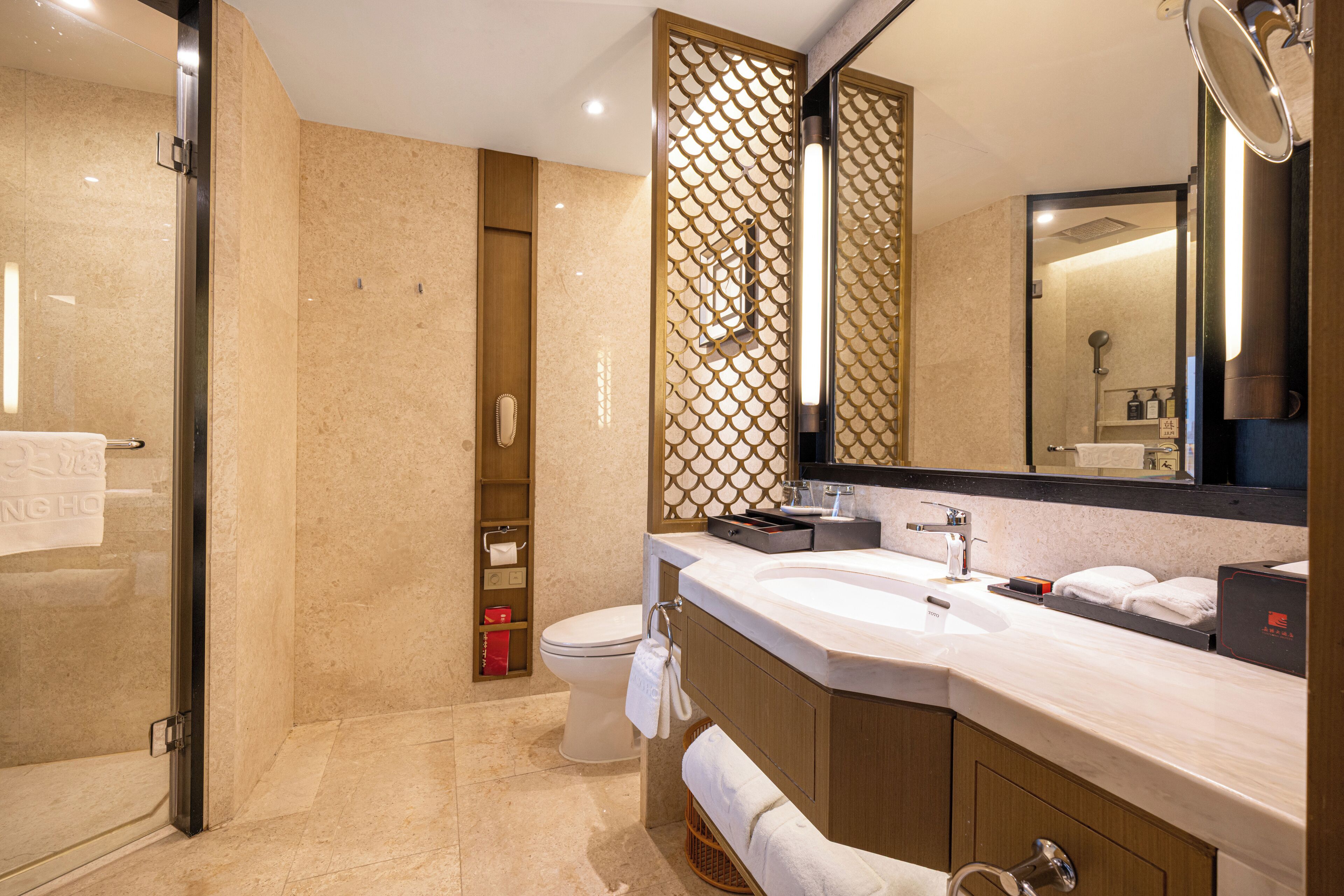 A modern bathroom with a large sink, mirror, and shower area.