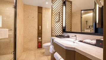 A modern bathroom with a large sink, mirror, and shower area.