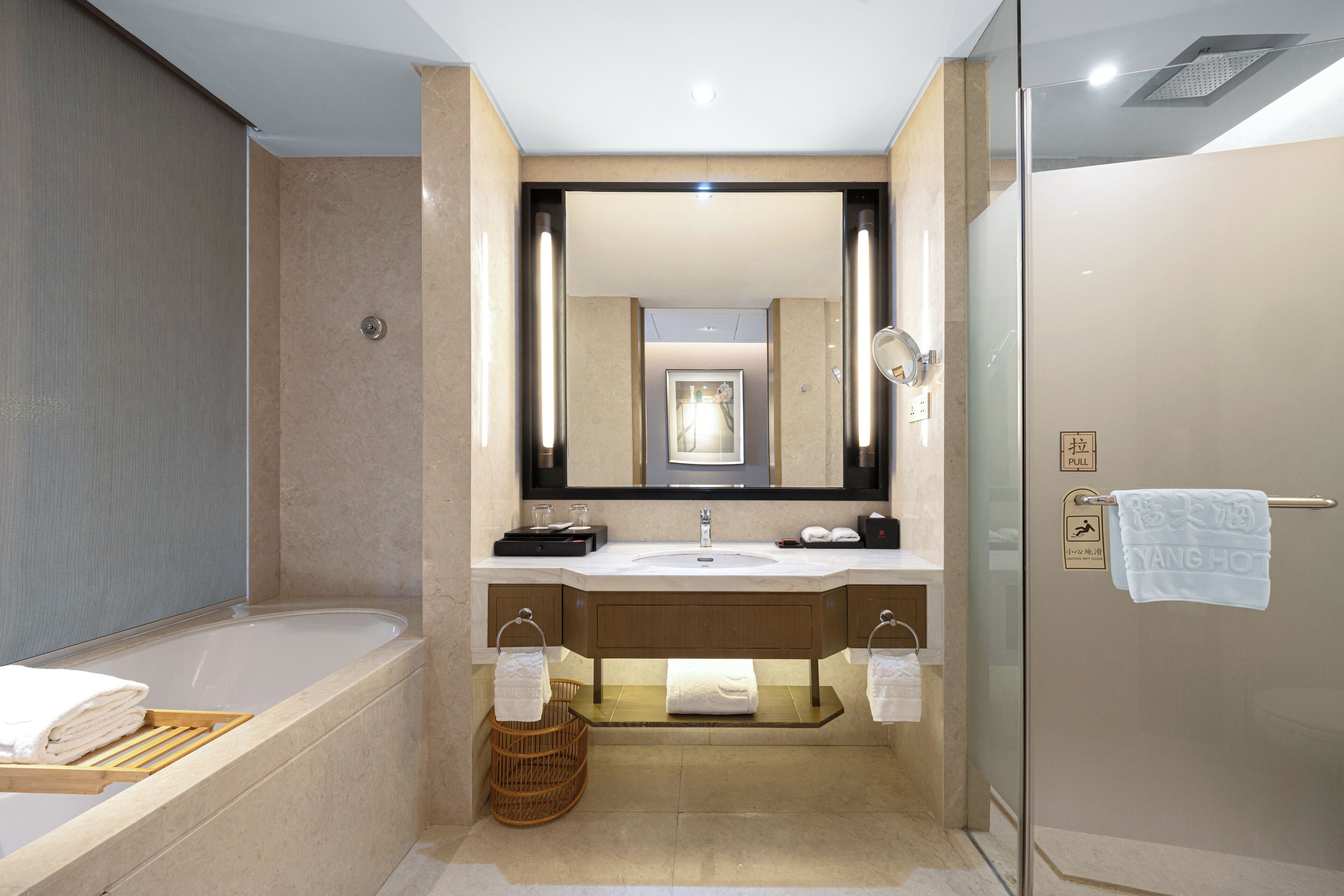 Un baño moderno con bañera, lavamanos y ducha con mampara de vidrio.