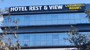 A hotel sign with "HOTEL REST & VIEW LUXURIOUS ROOMS" written on it. - Hotel Restandview (Anand)