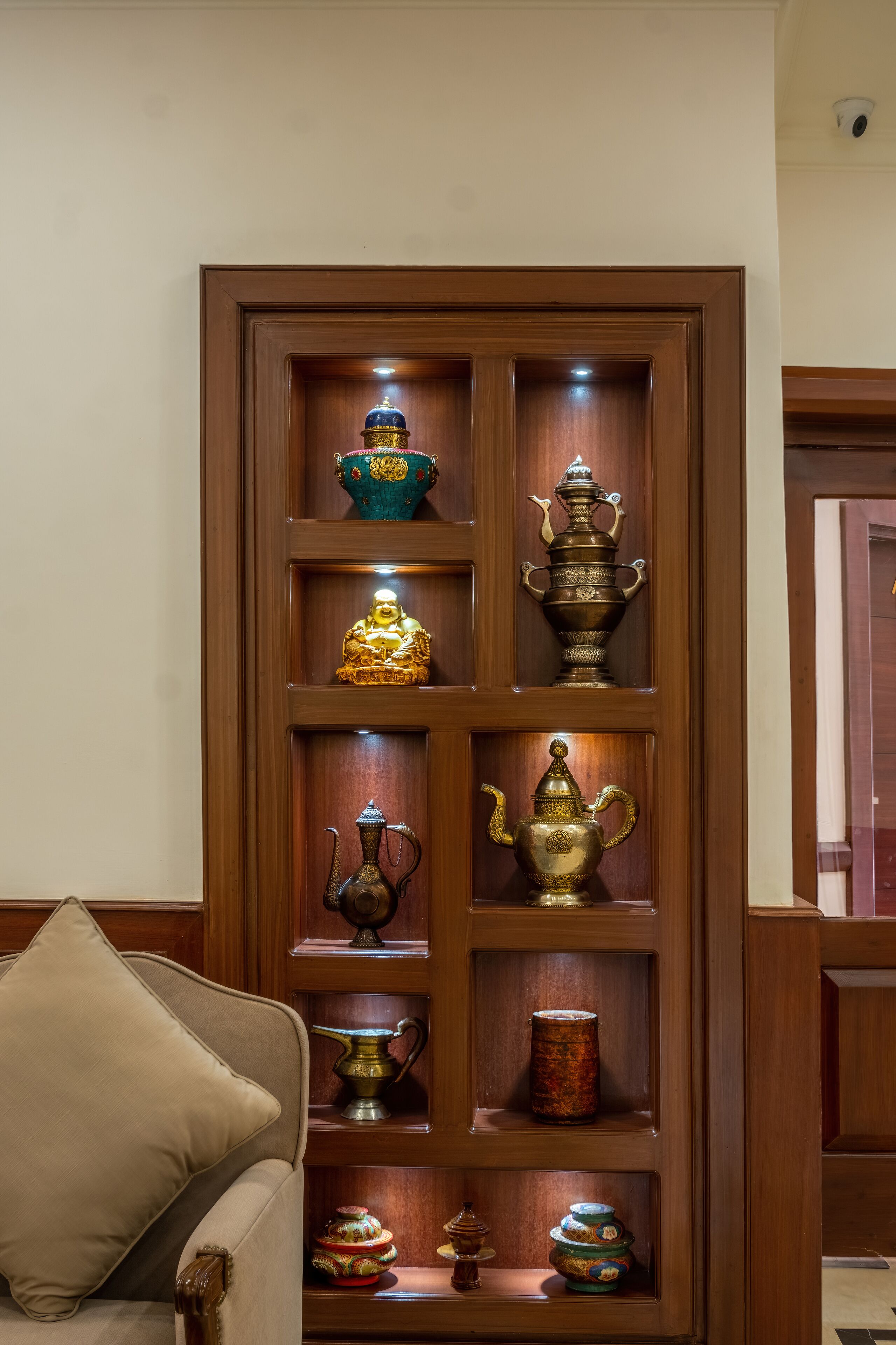Un aparador de madera con varios juegos de té tradicionales y recipientes.